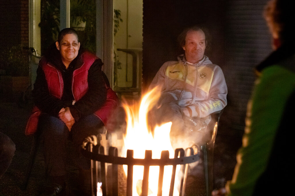 Die Bewohner genießen einen Abend am Feuerkorb.
