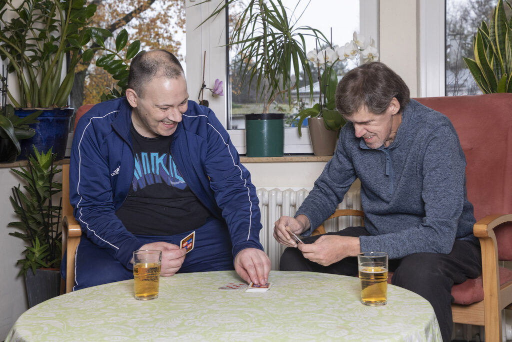 Zwei Bewohner spielen Karten.