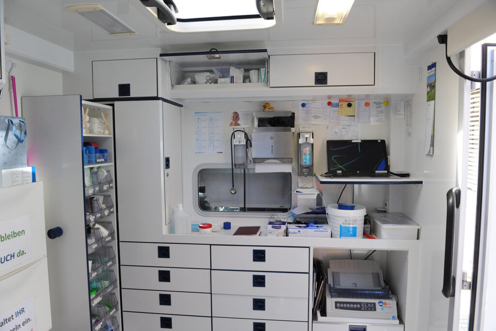 Blick in das GSE-Arztmobil, in dem neben einer Patientenliege viel medizinisches Equipment an Bord ist.