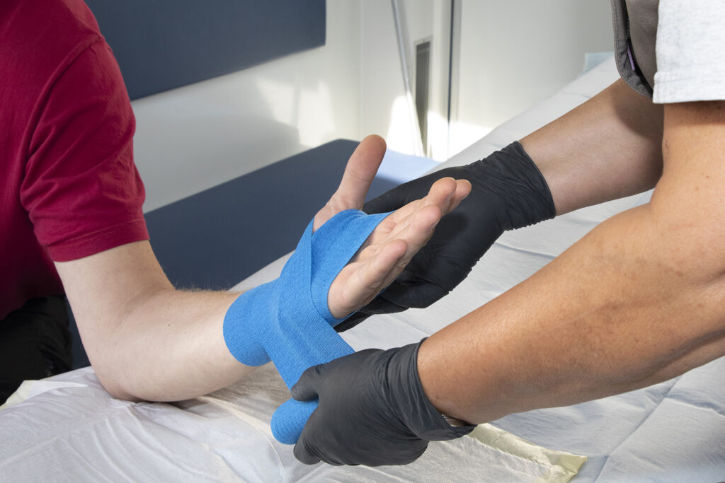 Einem Patienten wird die Hand verbunden.